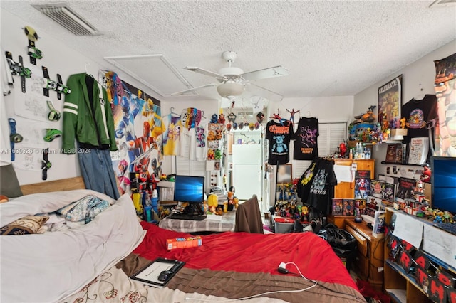 bedroom with ceiling fan, visible vents, and a textured ceiling