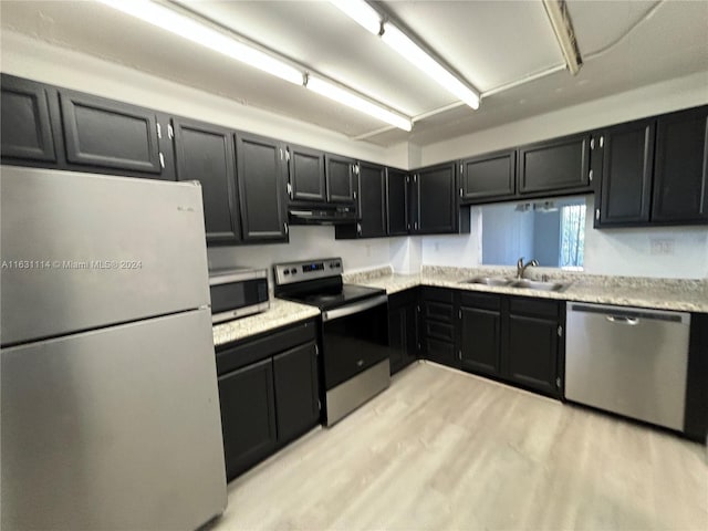 kitchen with light wood-type flooring, stainless steel appliances, and sink