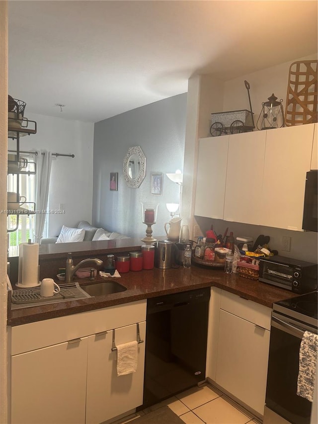 kitchen with sink, white cabinetry, light tile patterned flooring, stainless steel range with electric stovetop, and dishwasher