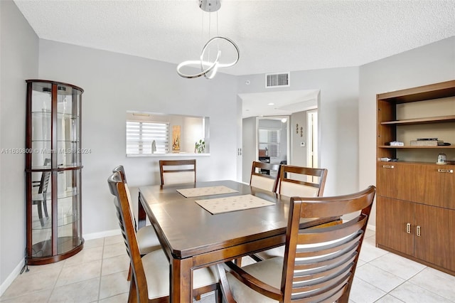 tiled dining area featuring a textured ceiling