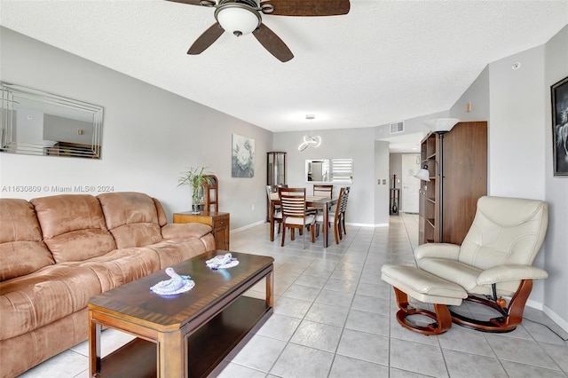 tiled living room featuring a textured ceiling and ceiling fan