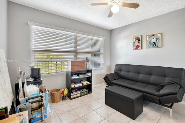 living room with light tile patterned flooring, a textured ceiling, and ceiling fan