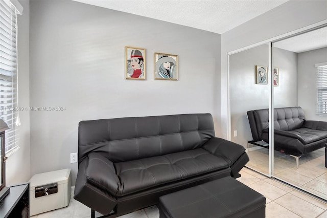 tiled living room featuring a textured ceiling