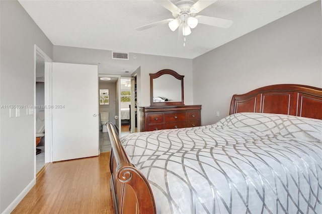 bedroom featuring a textured ceiling, light wood-type flooring, and ceiling fan