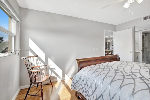 bedroom featuring a textured ceiling, light wood-type flooring, and ceiling fan