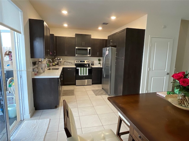 kitchen with sink, stainless steel appliances, and light tile patterned floors