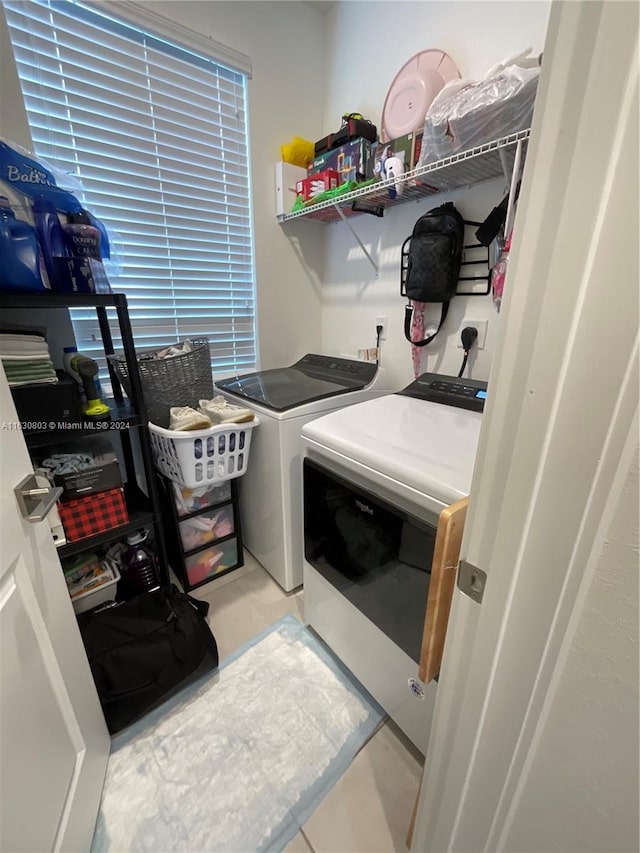 clothes washing area with light tile patterned floors and washing machine and clothes dryer