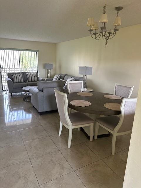 dining area featuring tile patterned floors and an inviting chandelier