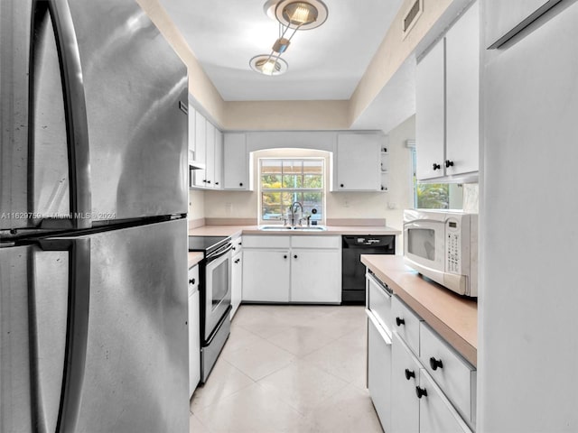 kitchen with black appliances, white cabinetry, and sink