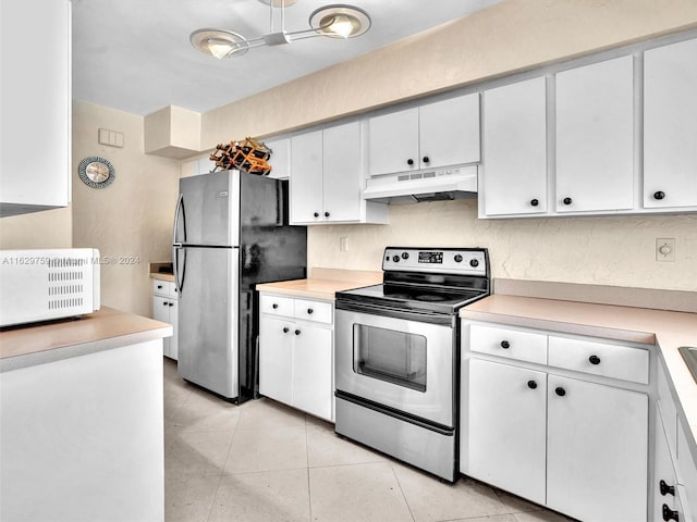 kitchen with appliances with stainless steel finishes, white cabinetry, and light tile patterned flooring