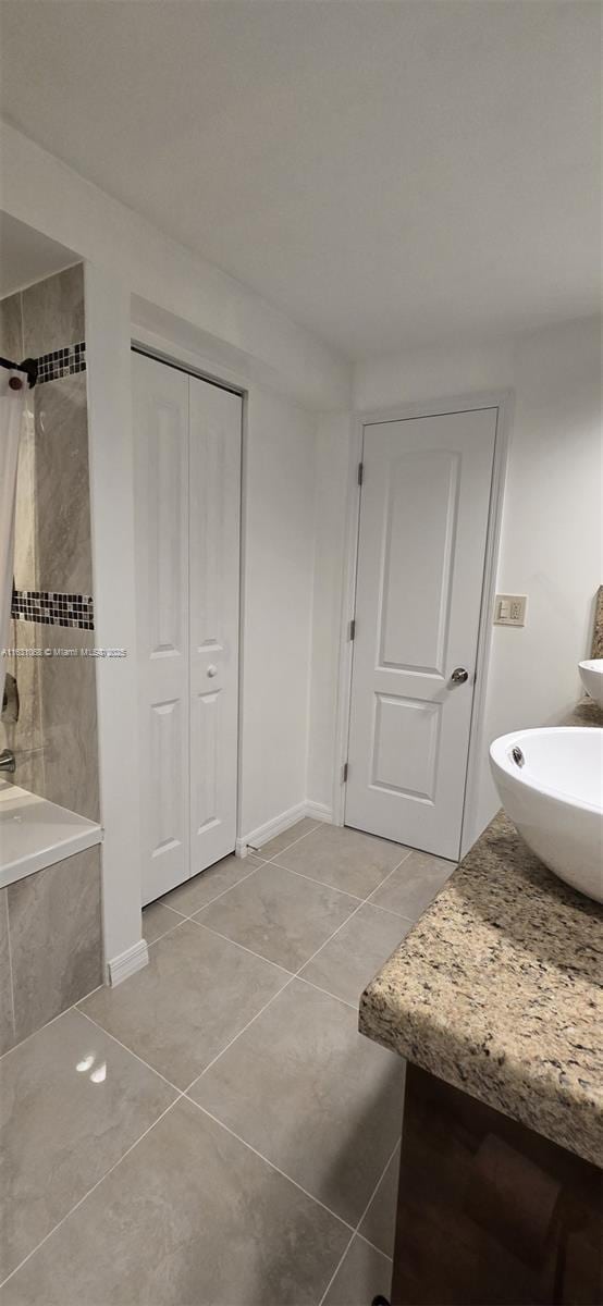 bathroom featuring vanity, tile patterned flooring, and tiled shower / bath