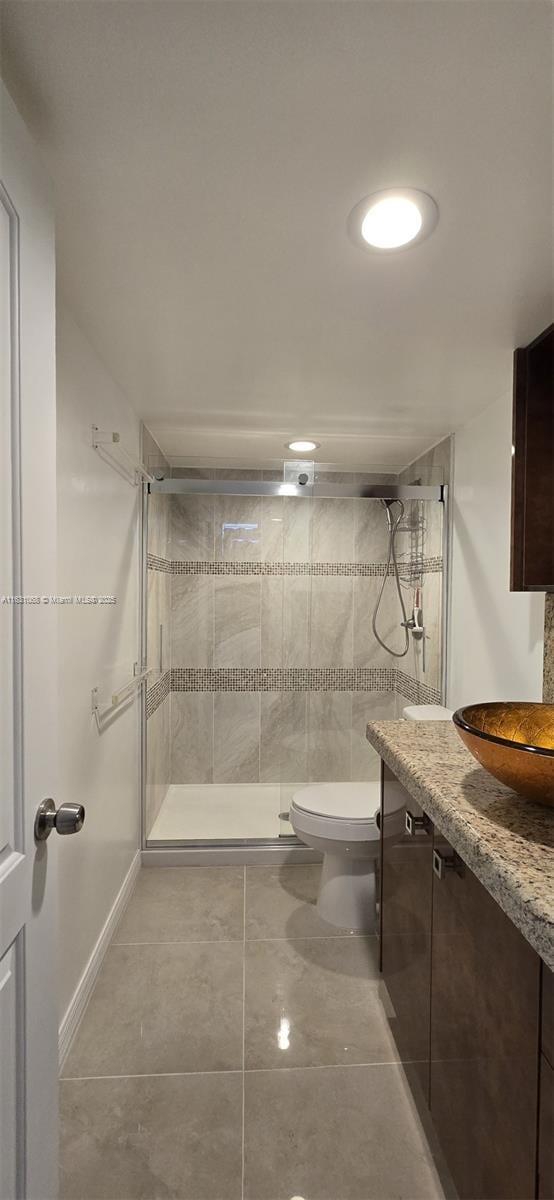 bathroom featuring vanity, toilet, and a shower with shower door