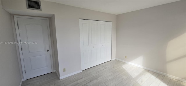 unfurnished bedroom with a closet and light hardwood / wood-style flooring