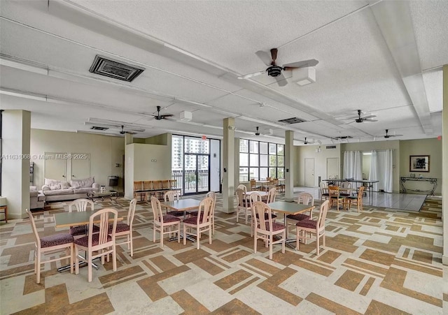 dining area featuring ceiling fan and a textured ceiling