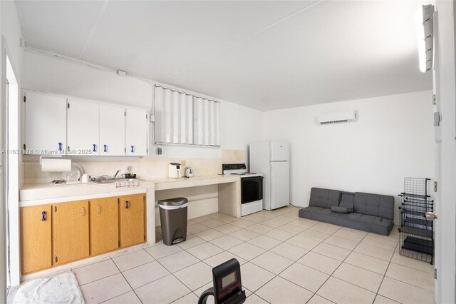 kitchen featuring white appliances, white cabinets, a wall mounted AC, and light tile patterned flooring