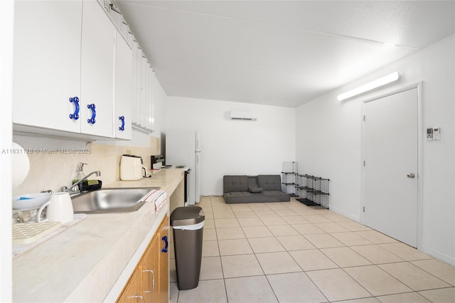 kitchen with light tile patterned floors, sink, electric range oven, and white cabinets