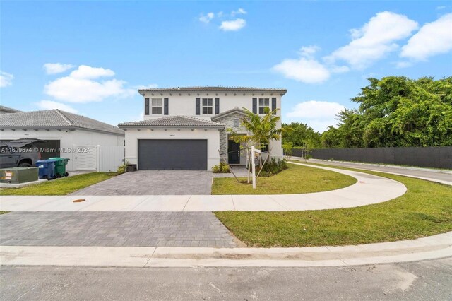 mediterranean / spanish house featuring a garage and a front lawn