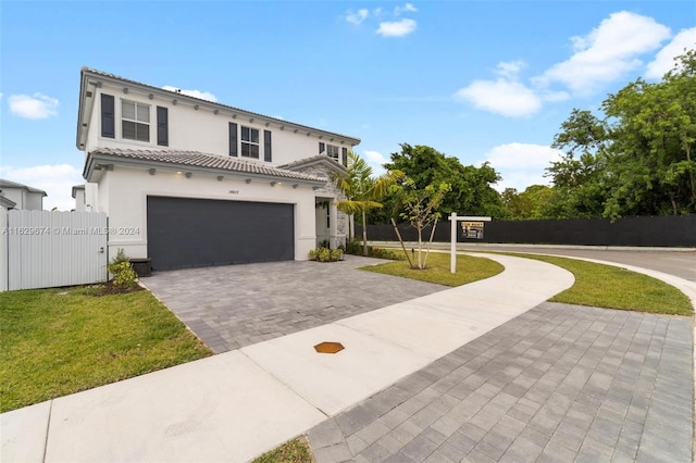 mediterranean / spanish home with a garage and a front lawn