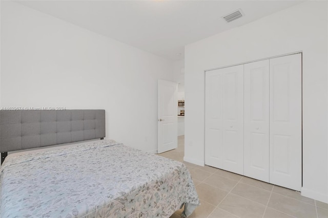 tiled bedroom with a closet