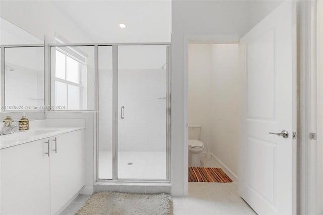 bathroom with vanity, tile patterned floors, a shower with door, and toilet