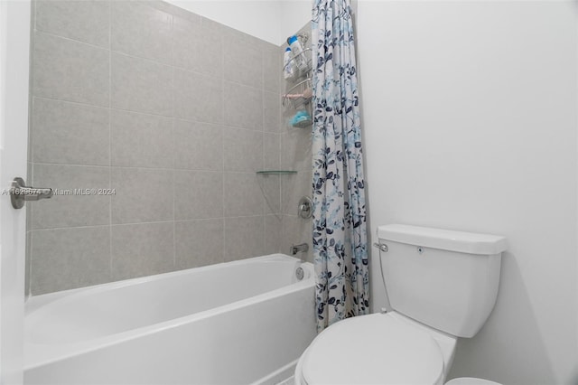 bathroom with shower / tub combo with curtain and toilet