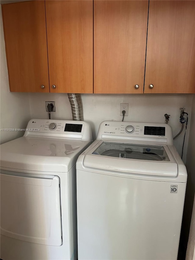 laundry room featuring cabinets and separate washer and dryer