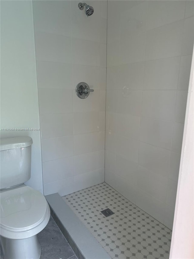 bathroom with tiled shower and toilet