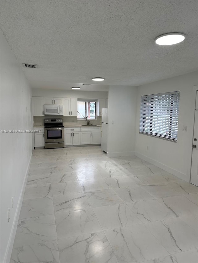 kitchen featuring white cabinets, white appliances, a textured ceiling, and sink