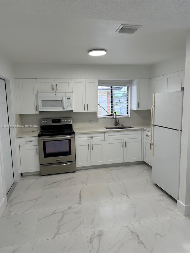 kitchen featuring white cabinets, a textured ceiling, sink, and white appliances