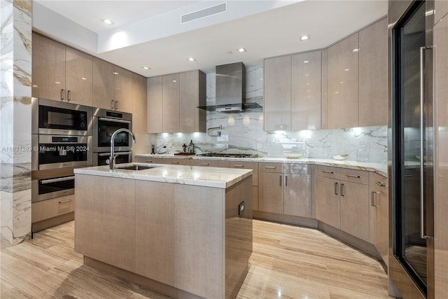 kitchen with light wood-type flooring, appliances with stainless steel finishes, tasteful backsplash, and wall chimney exhaust hood