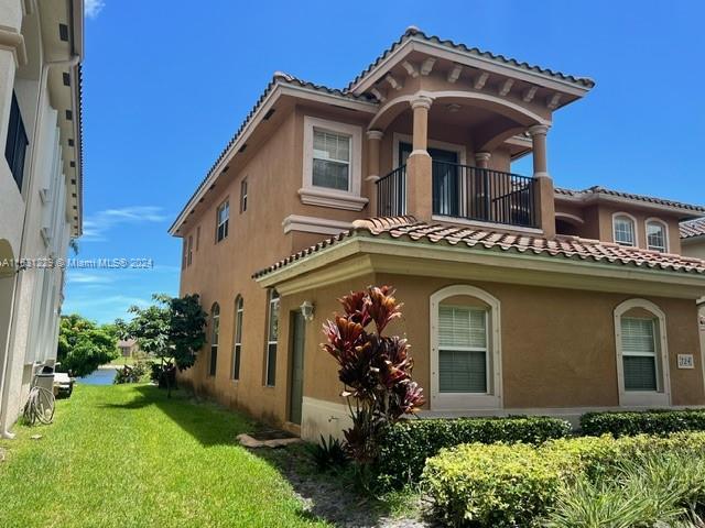 exterior space featuring a balcony and a yard