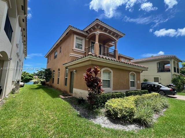 exterior space with a balcony and a lawn