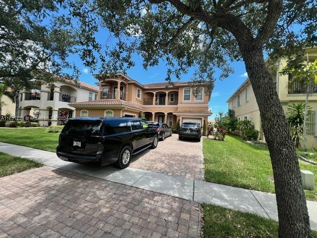 mediterranean / spanish-style home featuring a garage and a front yard