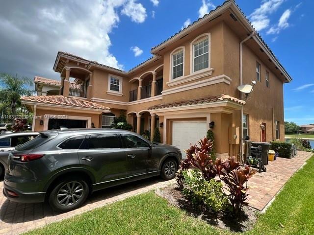 mediterranean / spanish-style house with a balcony and a garage