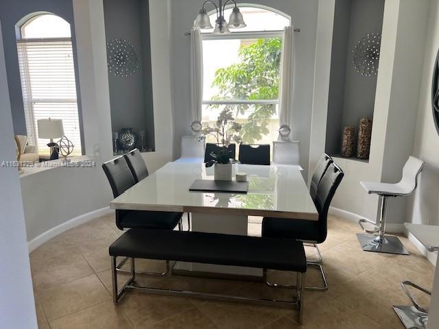 tiled dining space featuring a notable chandelier