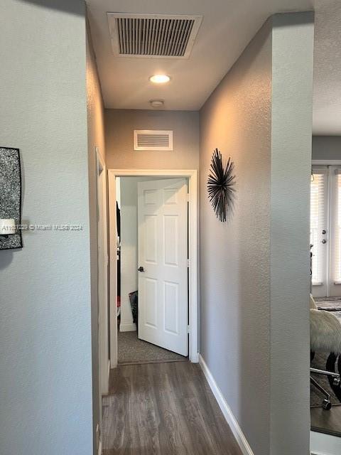 corridor with dark wood-type flooring and french doors