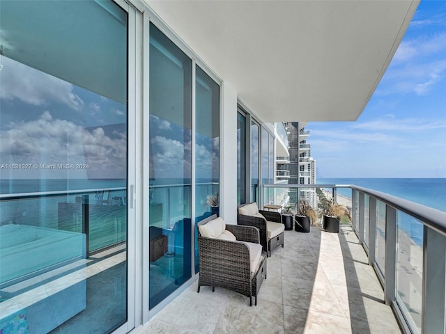 balcony featuring an outdoor living space and a water view