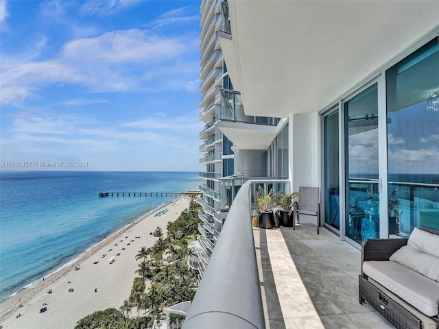 balcony featuring a water view and a view of the beach