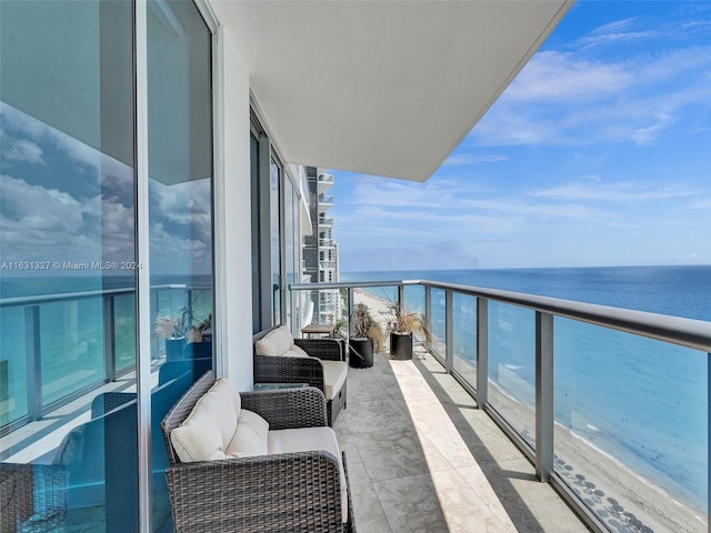 balcony featuring an outdoor living space, a water view, and a beach view