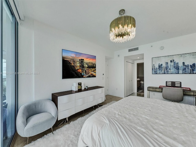 bedroom with connected bathroom and a chandelier