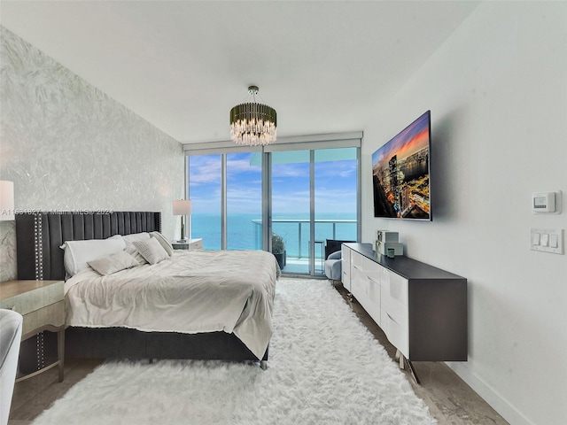 bedroom featuring a wall of windows, an inviting chandelier, and access to outside