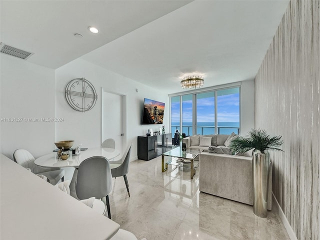 living room featuring light tile patterned flooring, an inviting chandelier, and expansive windows