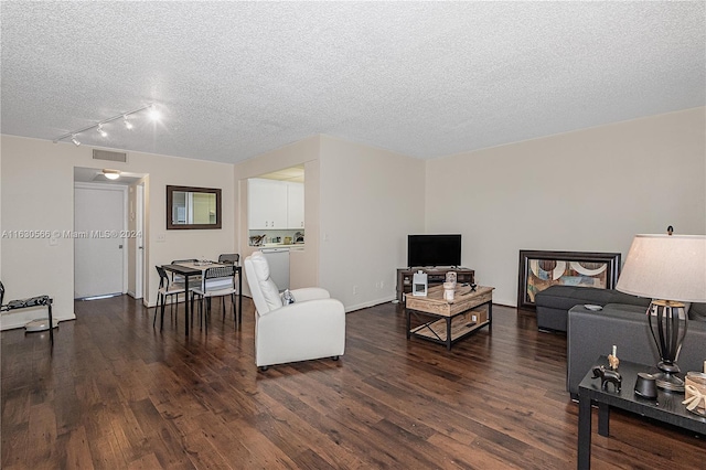 living room with dark hardwood / wood-style floors, a textured ceiling, and track lighting