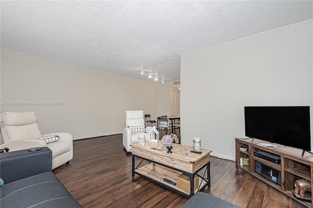 living room featuring dark hardwood / wood-style floors, a textured ceiling, and track lighting