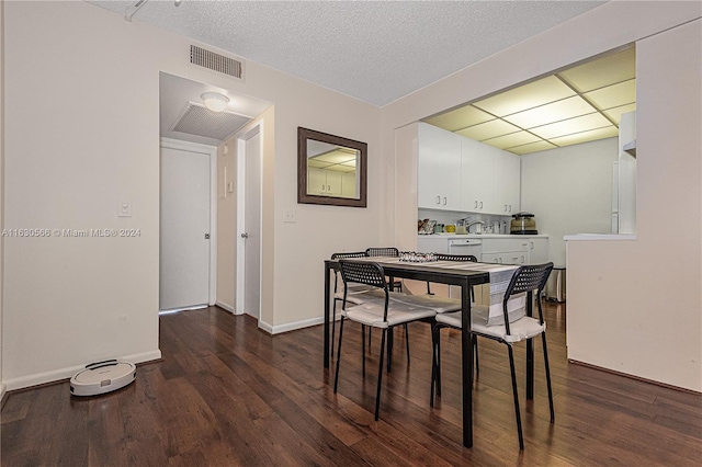 dining area featuring sink, a textured ceiling, and hardwood / wood-style flooring