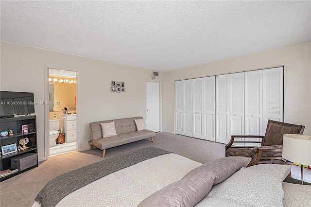 bedroom featuring ensuite bathroom, carpet, and a textured ceiling