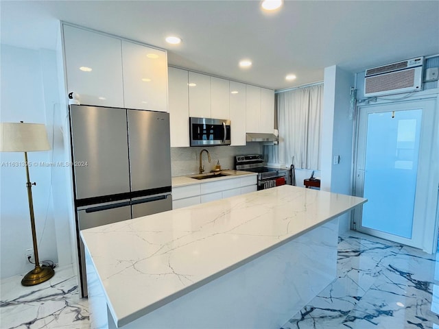 kitchen with appliances with stainless steel finishes, light stone counters, white cabinets, and sink