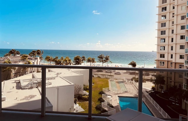 balcony featuring a patio, a water view, and a community pool