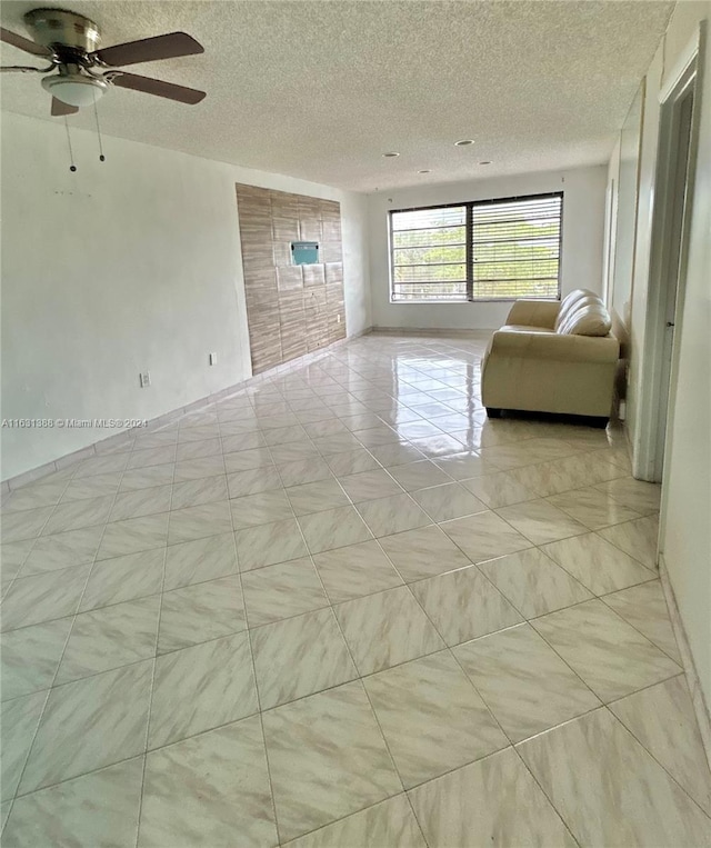 unfurnished living room featuring a textured ceiling and ceiling fan