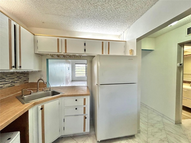 7480 NW 17th St Unit 305, Plantation, FL 33313 - kitchen featuring freestanding refrigerator, a sink, decorative backsplash, a textured ceiling, and light countertops